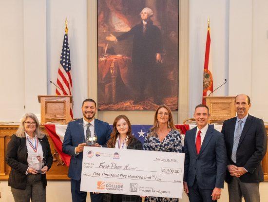 Associate Dean of Student Life at NFC Lynn Wyche, Commissioner of Education Anastasios Kamoutsas and first place winner Lillian Clay of NFC hold winning check.