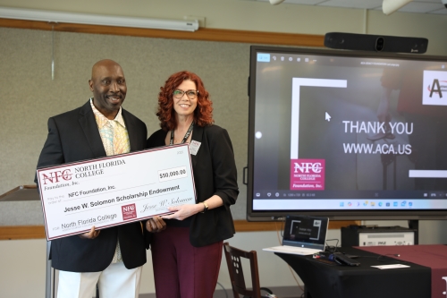 NFL Player Jesse Solomon and NFC Director of Resource Development Traci McClung hold check